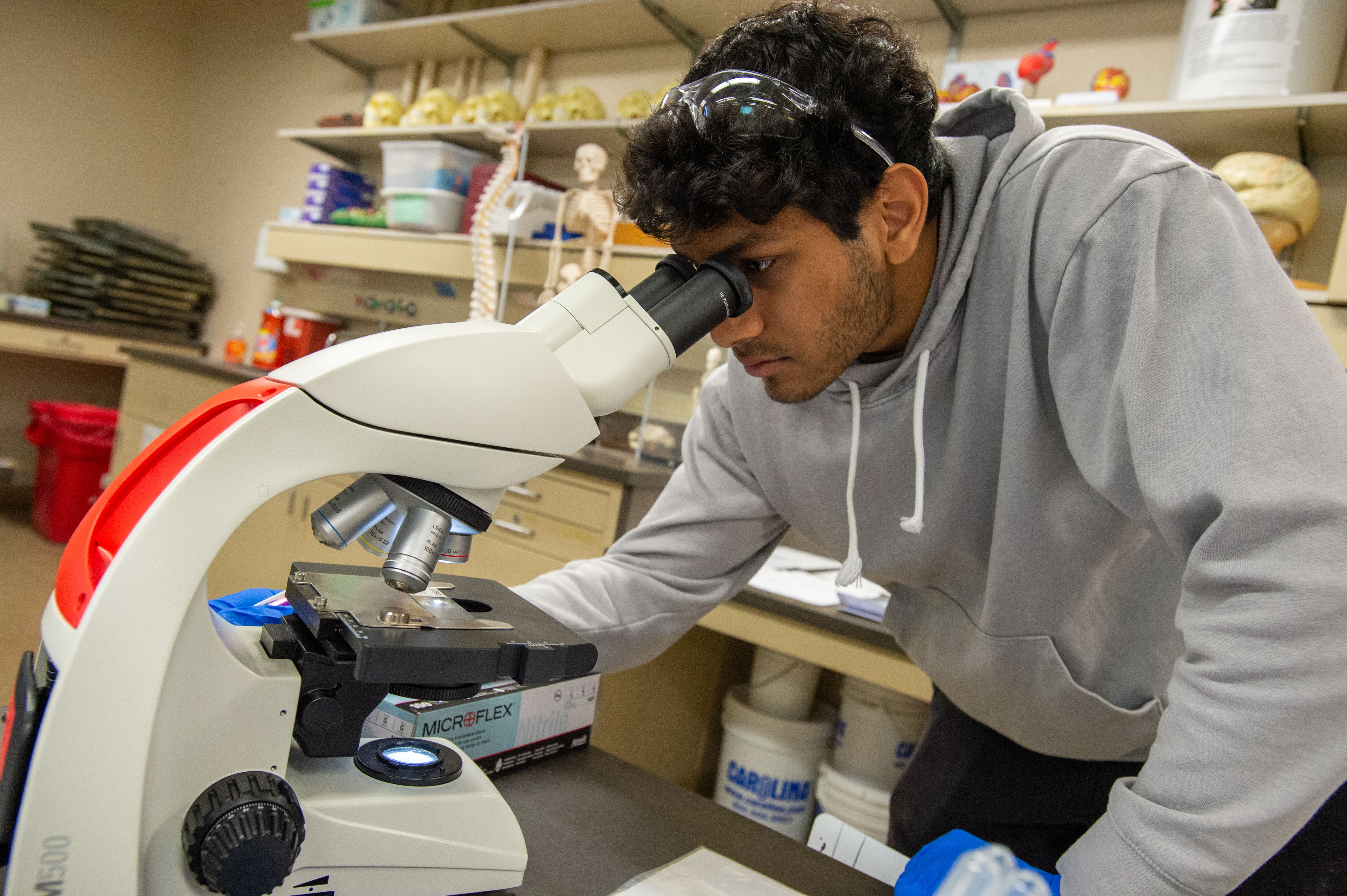 Student writing in notebook in lab